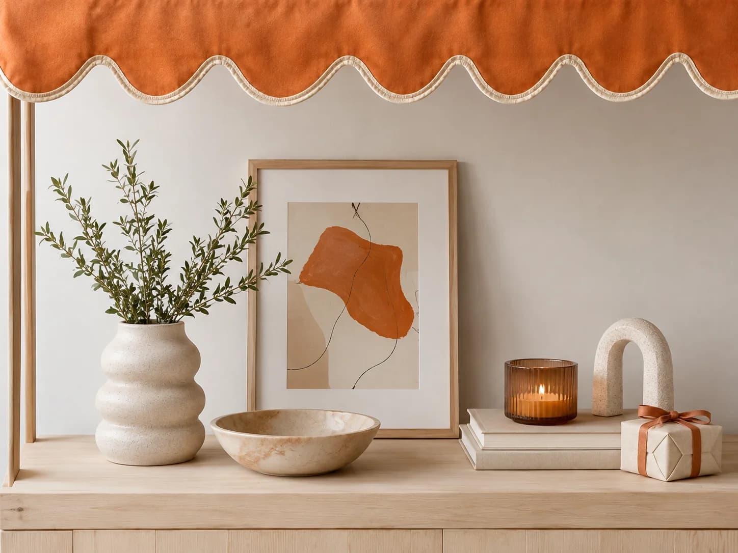 Handmade ceramics, dried grasses and a candle on a wooden table, with the words "Meet the makers"